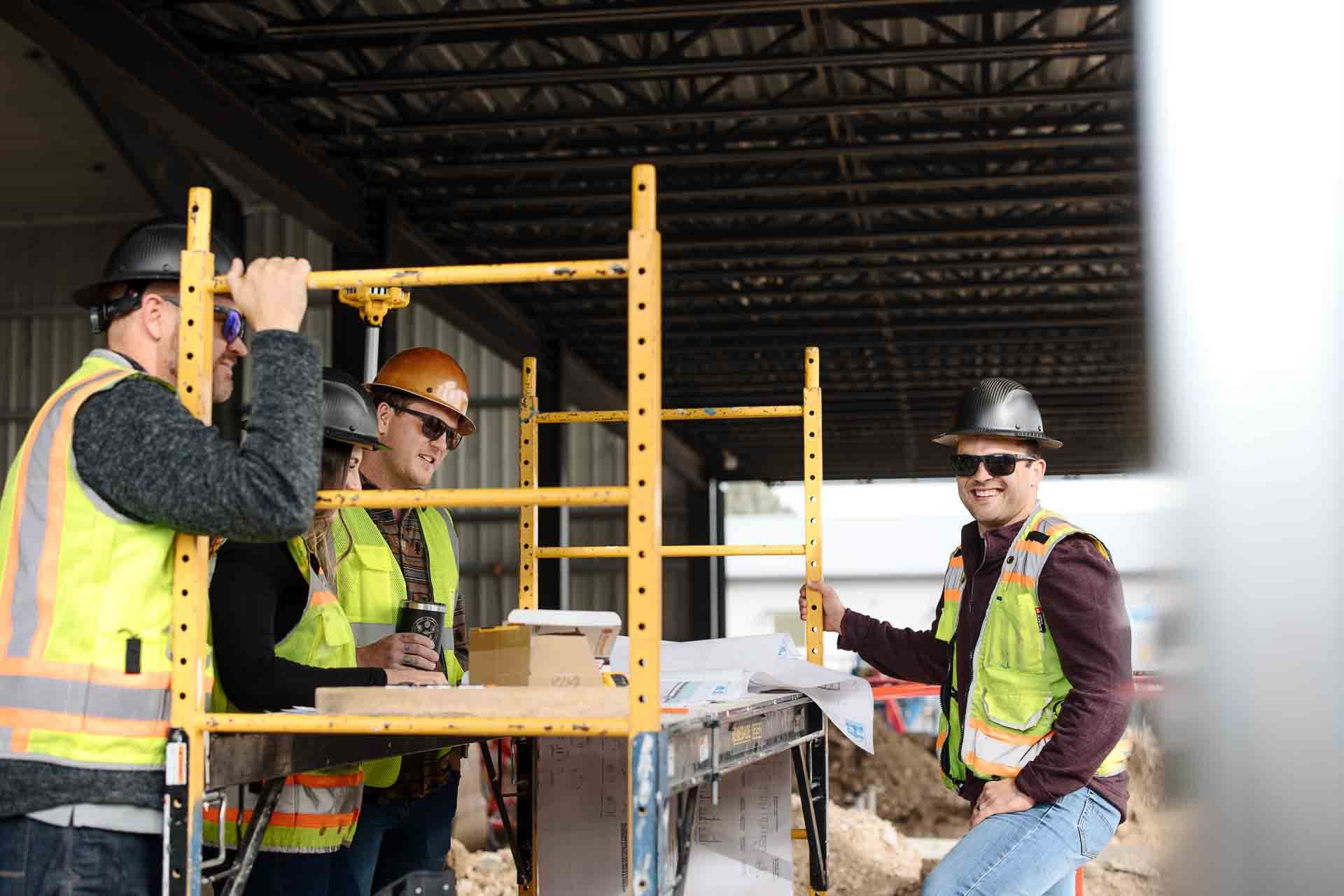 Hall & Hill crew reviewing drawings together on an organised, active job site