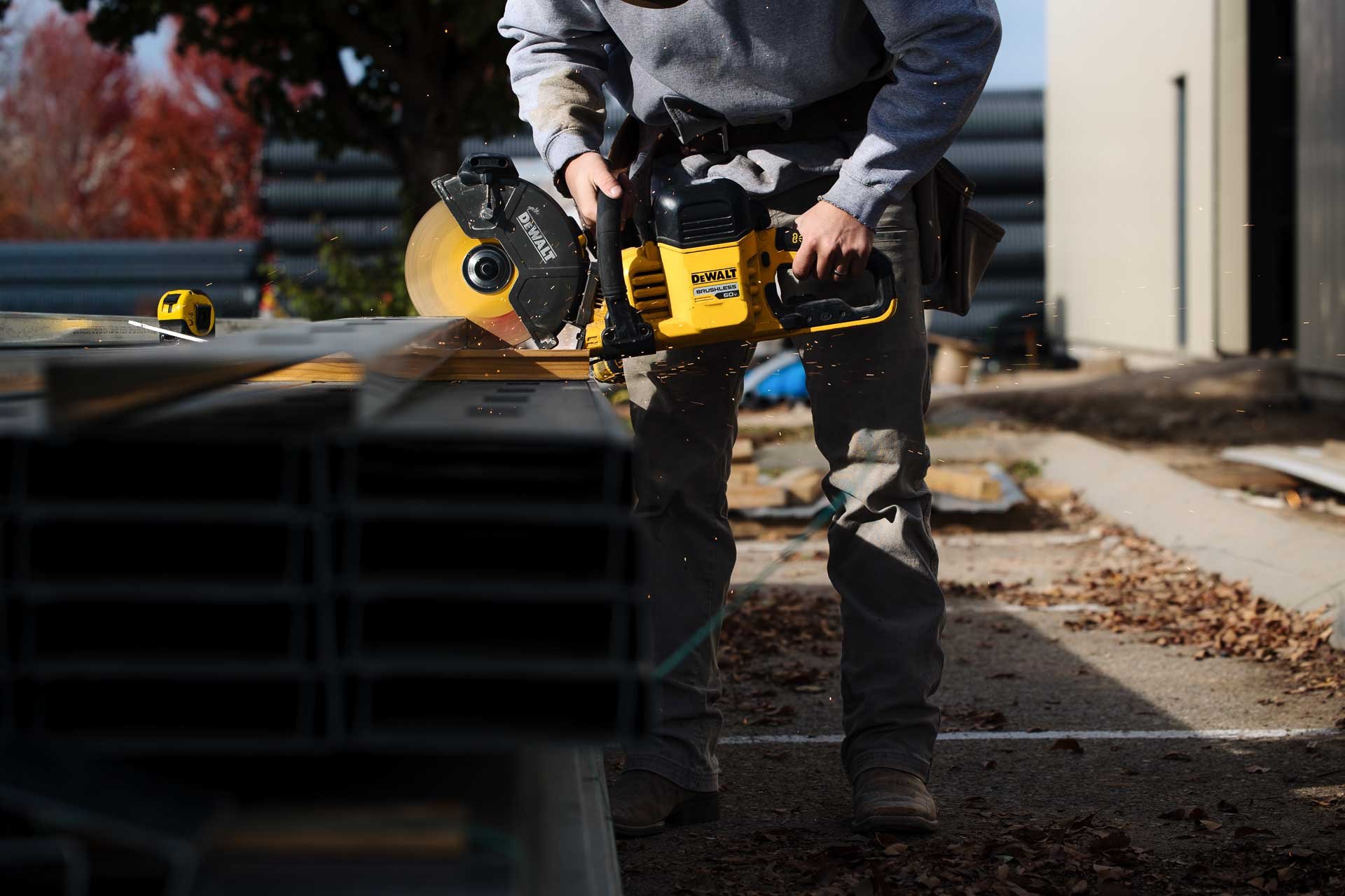 Tradesman cutting steel stud with a circular saw on a Hall & Hill job site
